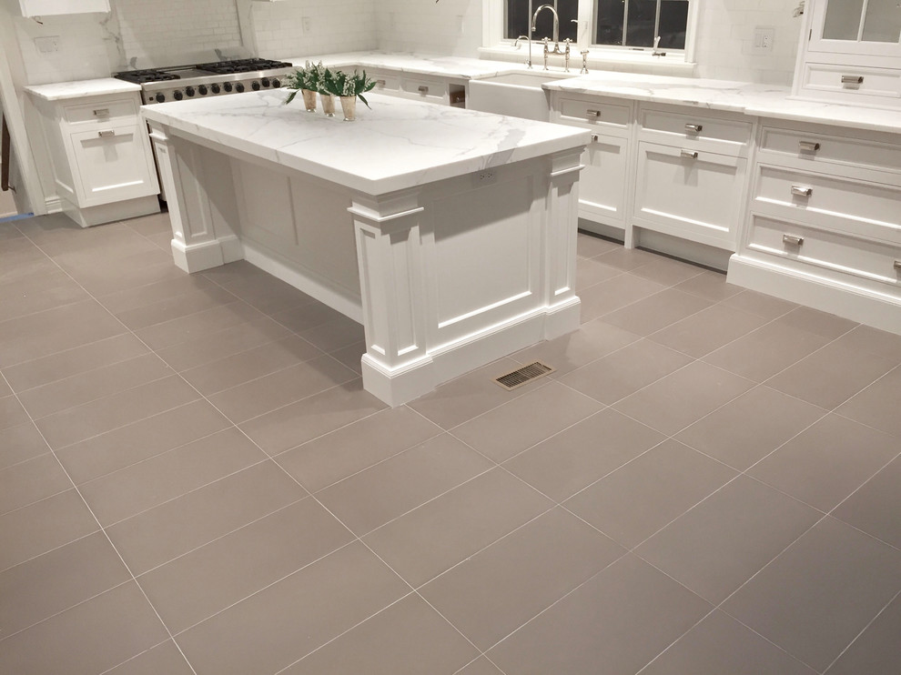 Eat-in kitchen - large transitional l-shaped beige floor eat-in kitchen idea with a farmhouse sink, shaker cabinets, white cabinets, white backsplash, stainless steel appliances and an island