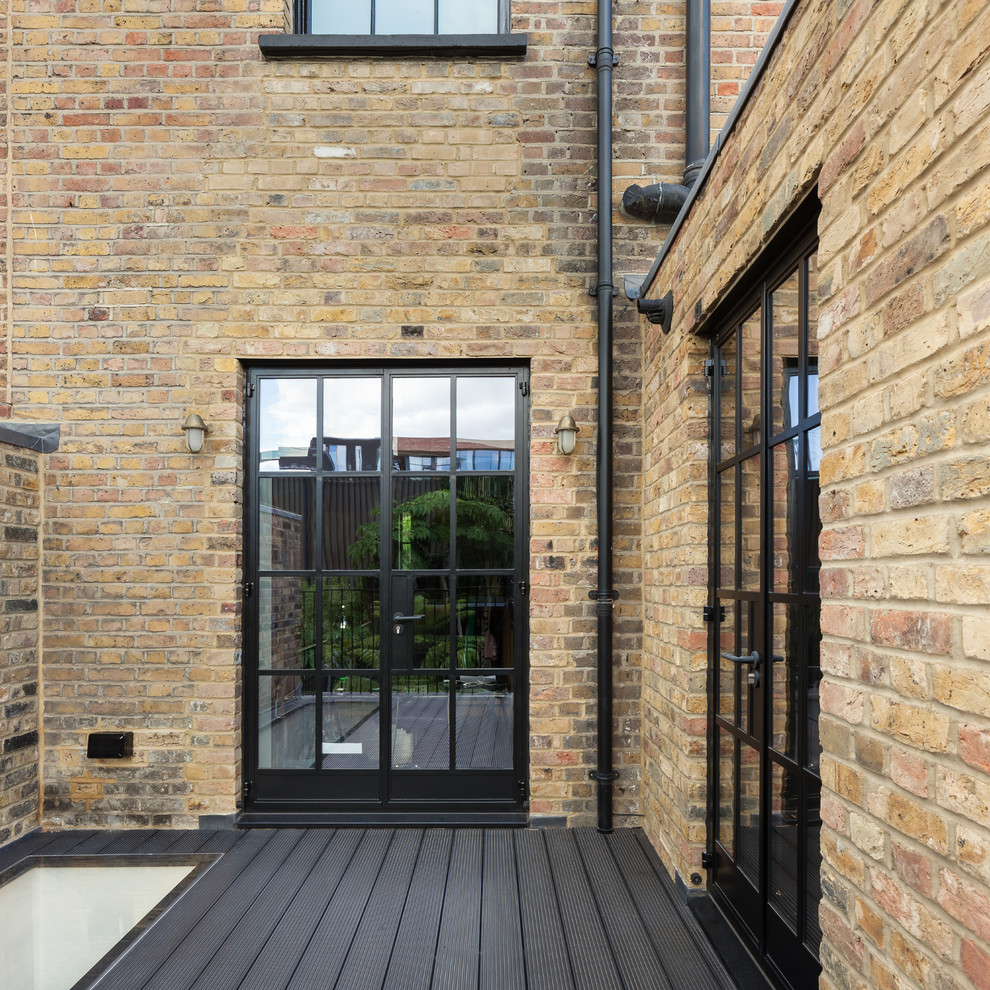 This is an example of a mid-sized contemporary rooftop deck in London with a roof extension.