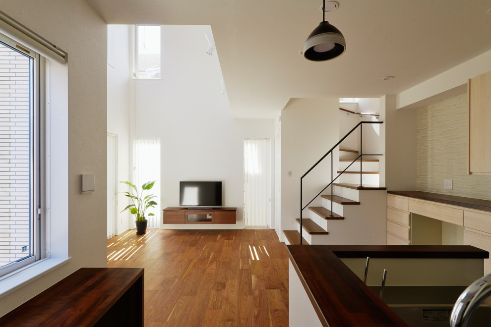 This is an example of a modern open plan dining in Tokyo Suburbs with white walls and plywood floors.