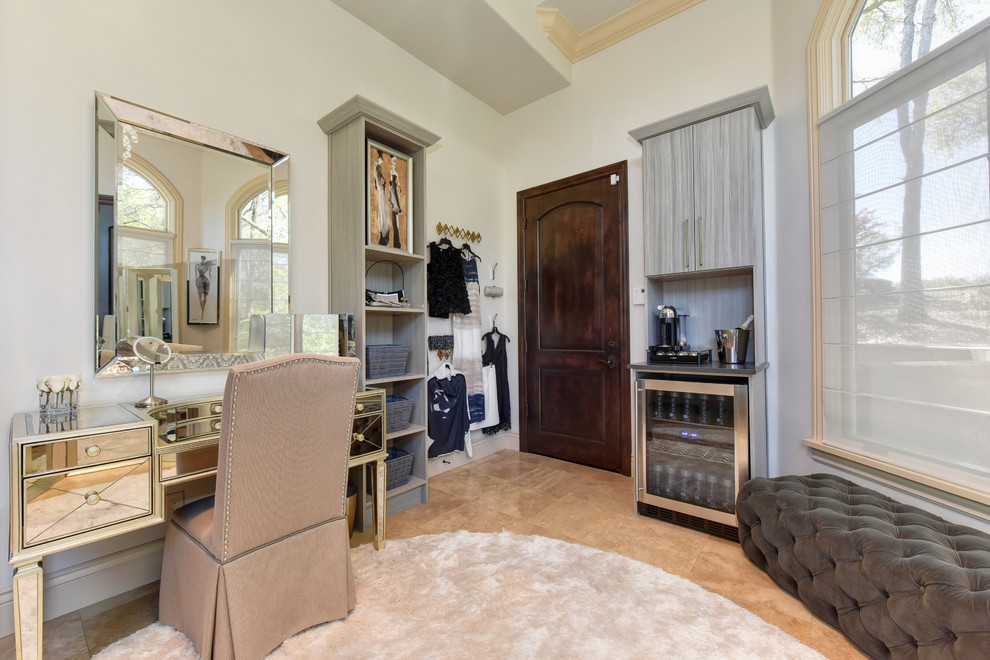 This is an example of an expansive transitional women's dressing room in Sacramento with open cabinets, grey cabinets, limestone floors and beige floor.