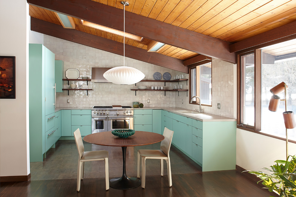 Photo of a midcentury u-shaped eat-in kitchen in New York with an undermount sink, flat-panel cabinets, green cabinets, white splashback, stainless steel appliances, dark hardwood floors, no island and brown floor.