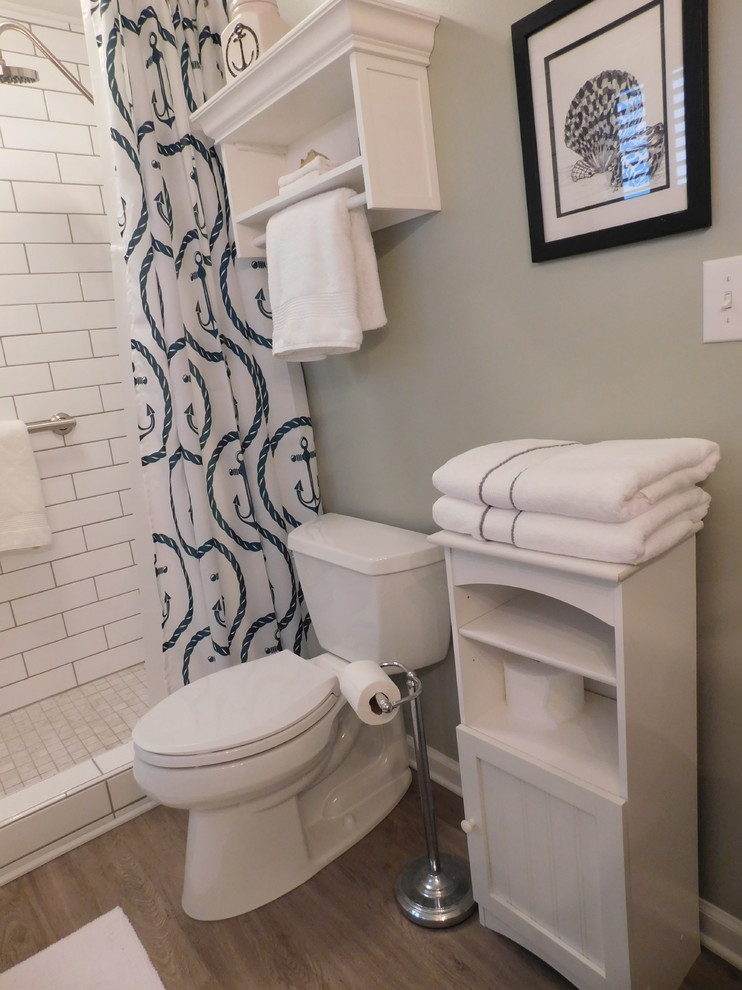Small beach style bathroom in Other with flat-panel cabinets, white cabinets, an alcove shower, a two-piece toilet, white tile, porcelain tile, grey walls, vinyl floors, an undermount sink and marble benchtops.