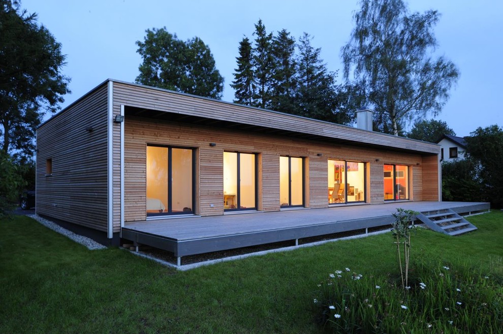 Photo of a mid-sized contemporary one-storey brown exterior in Other with wood siding and a flat roof.