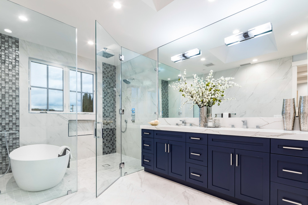This is an example of a transitional wet room bathroom in San Francisco with shaker cabinets, blue cabinets, a freestanding tub, an undermount sink, white floor, a hinged shower door, white benchtops, a niche, a double vanity and a built-in vanity.