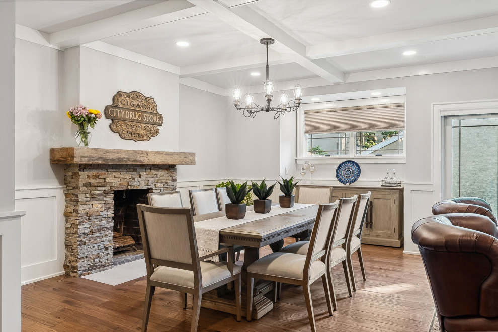 This is an example of a large traditional open plan dining in Columbus with grey walls, medium hardwood floors, a standard fireplace, brown floor, coffered and decorative wall panelling.