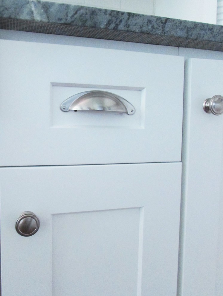 Enclosed kitchen - mid-sized transitional l-shaped medium tone wood floor enclosed kitchen idea with an undermount sink, shaker cabinets, white cabinets, soapstone countertops, white backsplash, subway tile backsplash, stainless steel appliances and a peninsula