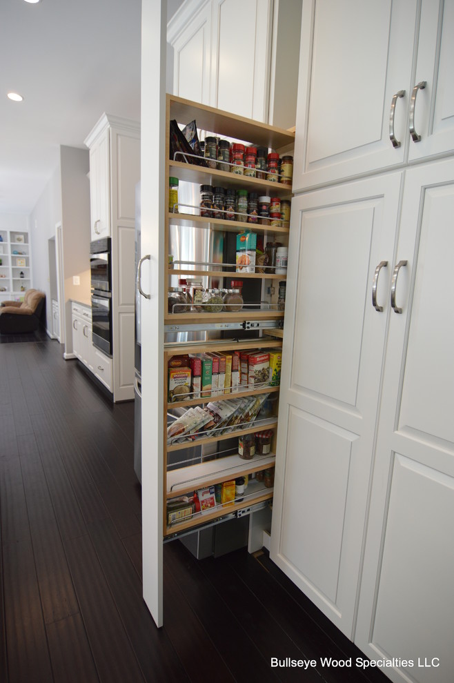 Inspiration for a large transitional u-shaped dark wood floor and brown floor eat-in kitchen remodel in DC Metro with an undermount sink, raised-panel cabinets, white cabinets, granite countertops, gray backsplash, glass tile backsplash, stainless steel appliances and an island