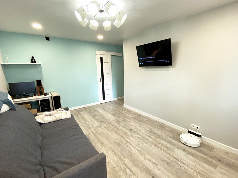 На фото: серо-белая гостиная комната среднего размера с серыми стенами, полом из винила, телевизором на стене, серым полом и обоями на стенах