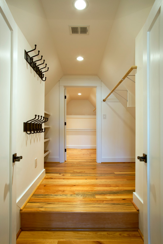 Photo of a country gender-neutral walk-in wardrobe in DC Metro with open cabinets, white cabinets and light hardwood floors.