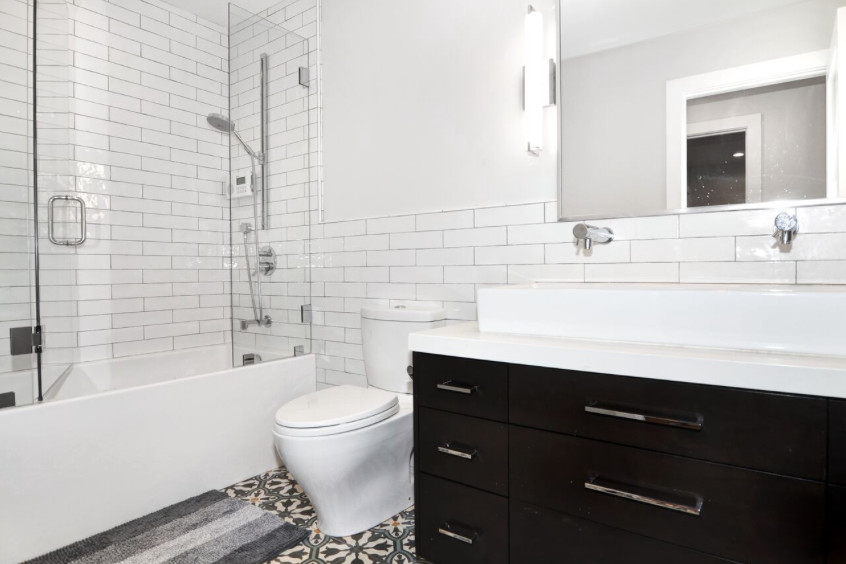 Inspiration for a mid-sized contemporary bathroom in Orange County with flat-panel cabinets, black cabinets, an alcove tub, a shower/bathtub combo, a two-piece toilet, gray tile, multi-coloured tile, white tile, yellow tile, subway tile, white walls, ceramic floors and an integrated sink.