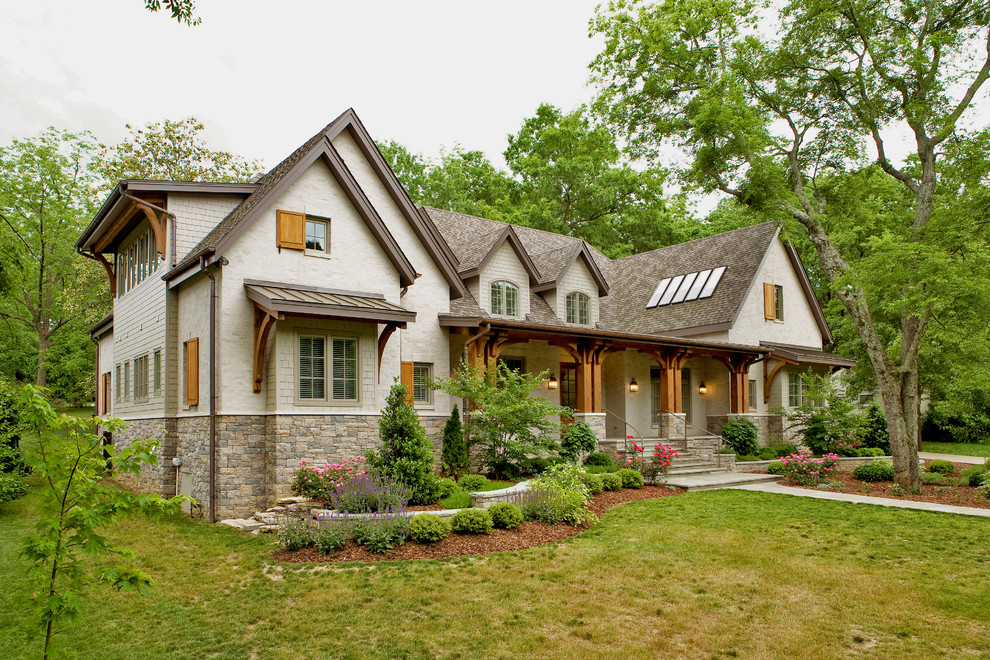 Mid-sized traditional two-storey beige house exterior in Nashville with stone veneer, a gable roof, a shingle roof, a brown roof and clapboard siding.