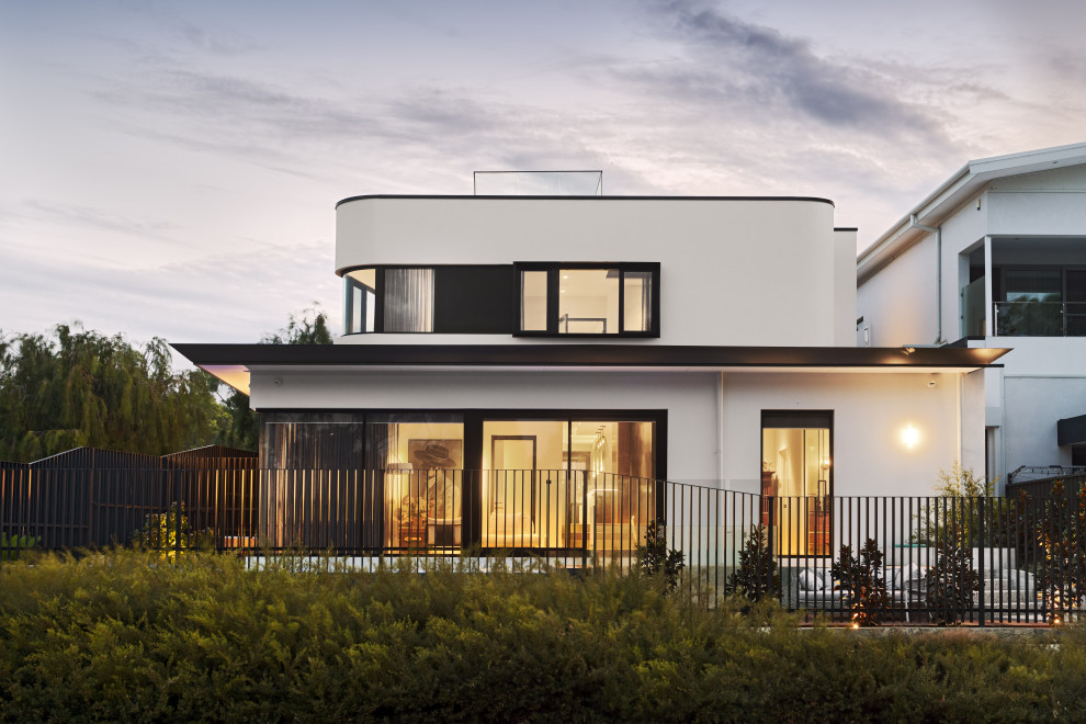 Photo of a mid-sized contemporary two-storey white house exterior in Perth with a flat roof.