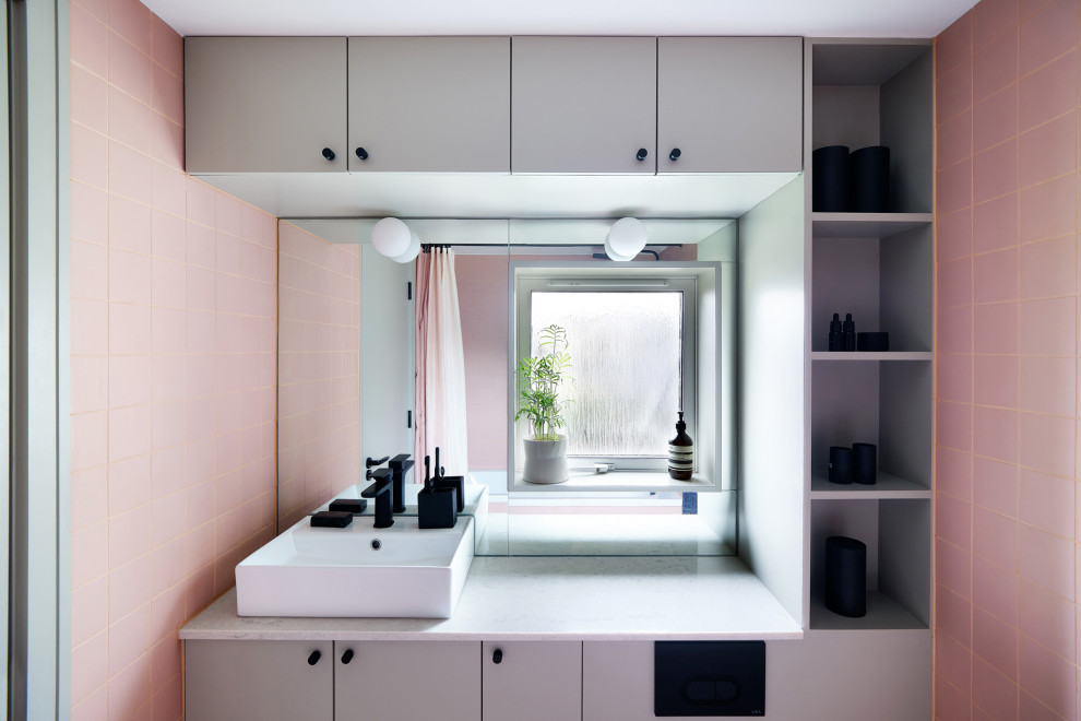 Photo of a mid-sized contemporary bathroom in London with flat-panel cabinets, grey cabinets, a drop-in tub, pink tile, porcelain tile, pink walls, porcelain floors, quartzite benchtops, grey floor, grey benchtops, a niche, a single vanity, a built-in vanity and a vessel sink.