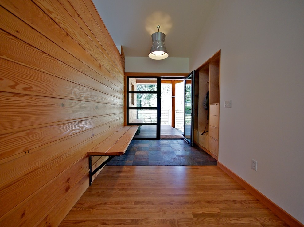 Design ideas for a contemporary entry hall in Seattle with white walls, medium hardwood floors, a single front door and a glass front door.