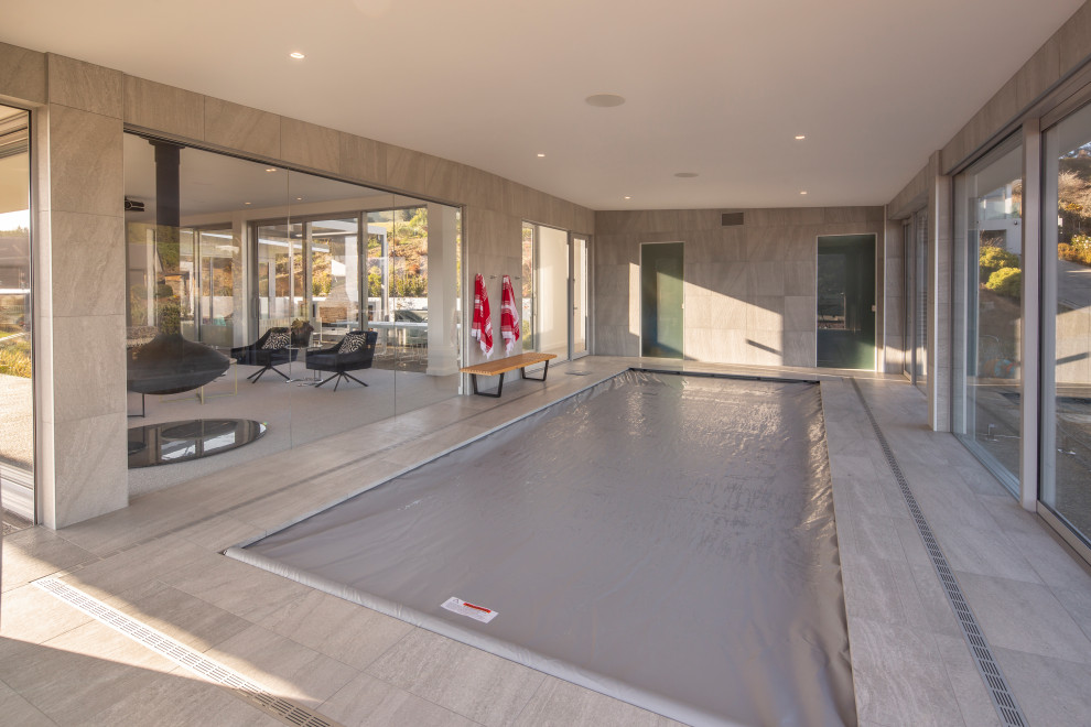 Large modern indoor rectangular natural pool in Dunedin with a pool house.