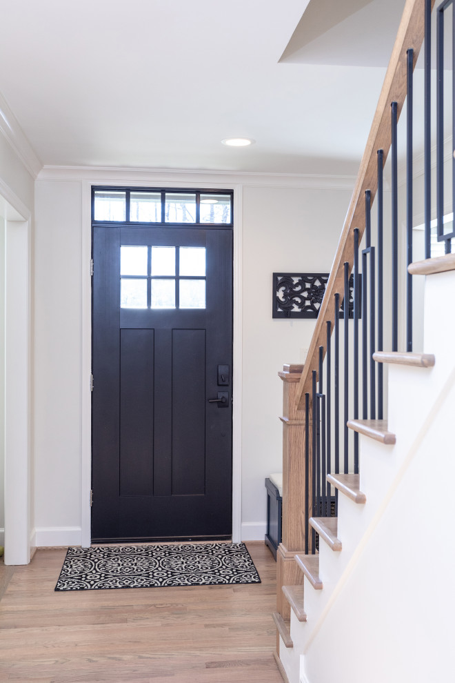 Foto de distribuidor clásico renovado de tamaño medio con paredes grises, suelo de madera en tonos medios, puerta simple, puerta negra y suelo marrón