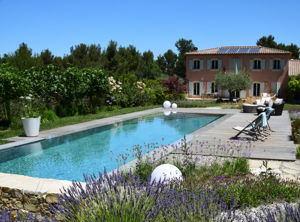 Inspiration for a large contemporary backyard rectangular infinity pool in Montpellier with decking.
