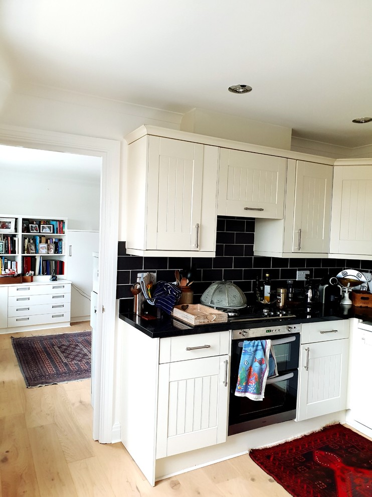 This is an example of a large traditional kitchen in London with medium hardwood floors, brown floor and recessed.