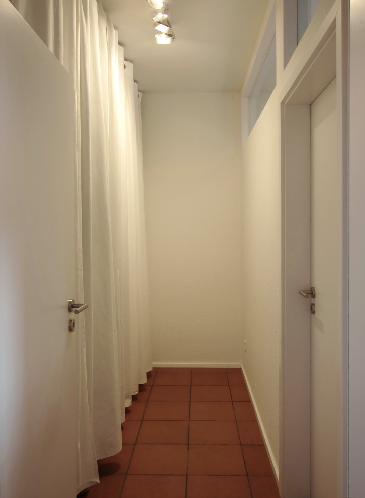 Esempio di un piccolo spazio per vestirsi unisex minimal con ante bianche e pavimento con piastrelle in ceramica