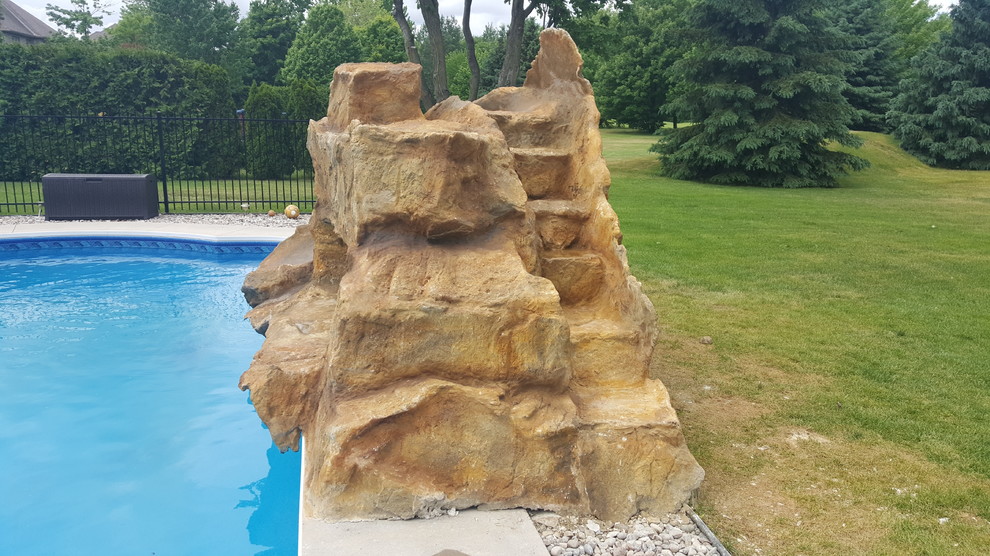 This is an example of a mid-sized traditional backyard rectangular pool in Ottawa with a water slide and concrete pavers.
