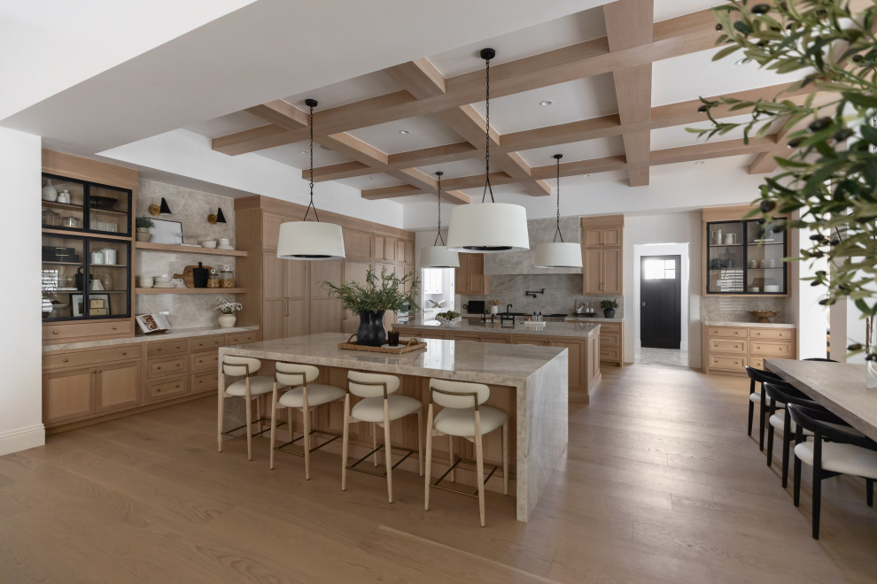 Worth the Wait - Transitional l-shaped light wood floor, beige floor and exposed beam open concept kitchen photo in Phoenix with an undermount sink, shaker cabinets, light wood cabinets, gray backsplash, stone slab backsplash, paneled appliances, two islands and gray countertops