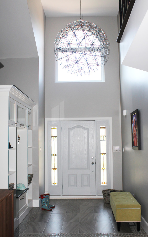 Inspiration for a large contemporary foyer in Montreal with grey walls, porcelain floors, a single front door and a glass front door.