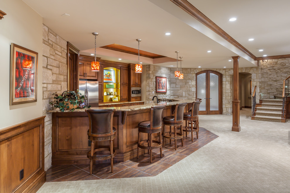 This is an example of a country seated home bar in Denver with raised-panel cabinets, medium wood cabinets, granite benchtops, multi-coloured splashback and porcelain floors.