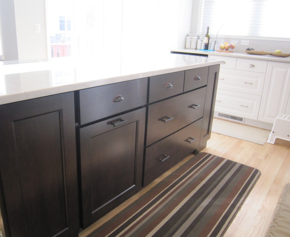 Example of a transitional light wood floor eat-in kitchen design in Chicago with recessed-panel cabinets, dark wood cabinets, marble countertops and an island