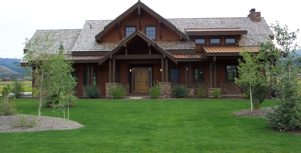 Large mountain style brown two-story wood gable roof photo with a shingle roof