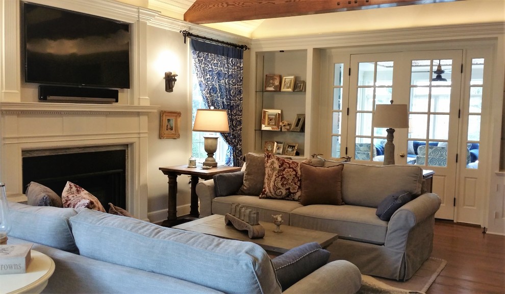 Photo of a traditional living room in Other with white walls, medium hardwood floors and a wood fireplace surround.