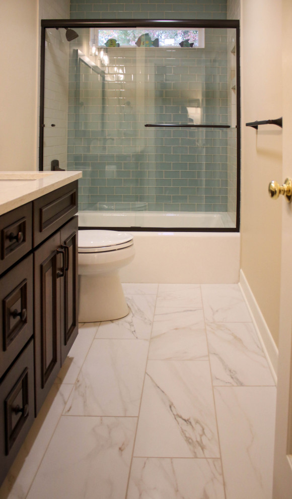 This is an example of a mid-sized traditional master bathroom in Cleveland with raised-panel cabinets, a one-piece toilet, white tile, subway tile, yellow walls, porcelain floors, an undermount sink, engineered quartz benchtops, white floor, a sliding shower screen, beige benchtops, a single vanity and a freestanding vanity.