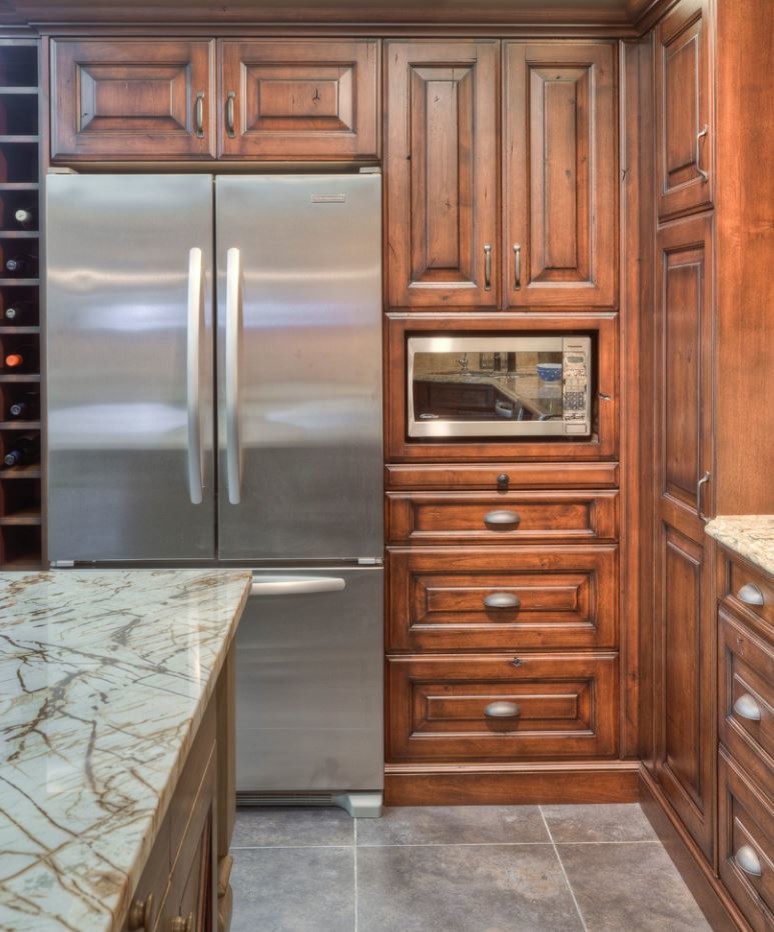 Eat-in kitchen - large rustic u-shaped porcelain tile eat-in kitchen idea in Toronto with an undermount sink, raised-panel cabinets, brown cabinets, quartz countertops, beige backsplash, stainless steel appliances and an island