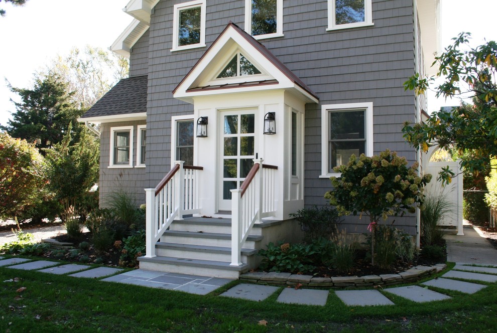 Photo of a mid-sized country two-storey grey exterior in New York with vinyl siding, a gable roof and a metal roof.