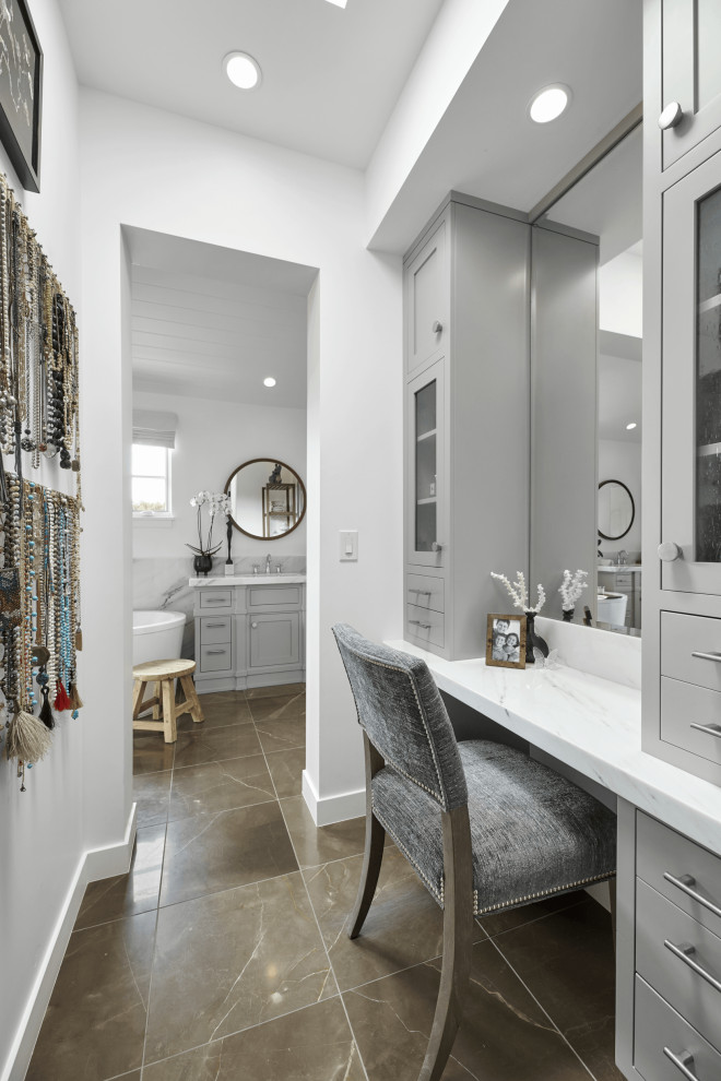 This is an example of a mid-sized beach style gender-neutral dressing room in Orange County with shaker cabinets, grey cabinets, porcelain floors, brown floor and vaulted.