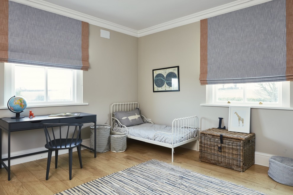 This is an example of a mid-sized scandinavian gender-neutral kids' bedroom for kids 4-10 years old in Dublin with beige walls, light hardwood floors and beige floor.