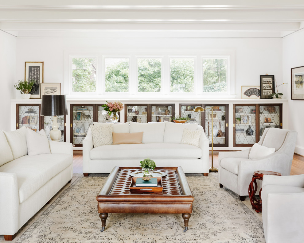 Esempio di un grande soggiorno classico con pareti bianche, pavimento in legno massello medio, pavimento marrone e travi a vista
