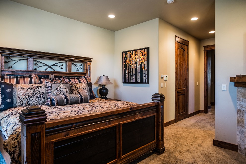 Inspiration for a mid-sized rustic master carpeted bedroom remodel with beige walls, a corner fireplace and a stone fireplace
