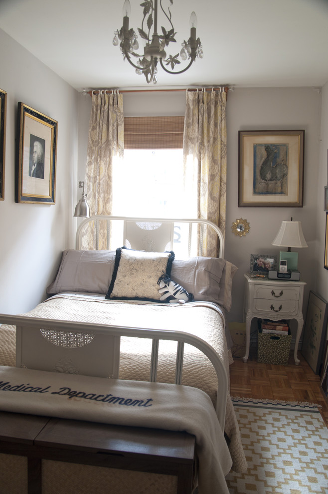 Photo of a small traditional bedroom in New York with grey walls and medium hardwood floors.