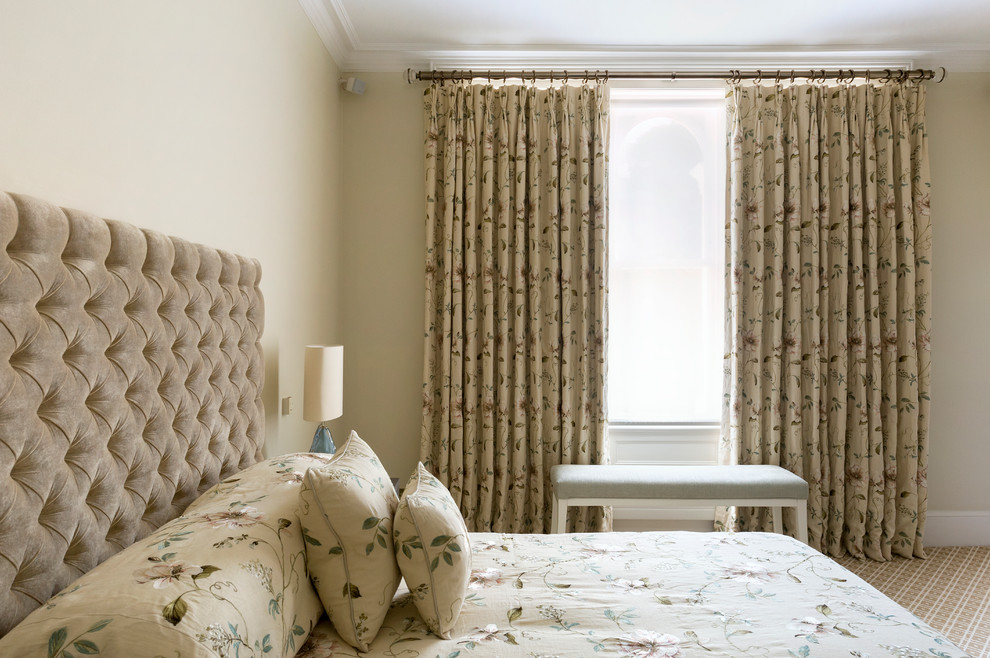 Inspiration for a mid-sized traditional bedroom in London with beige walls and carpet.