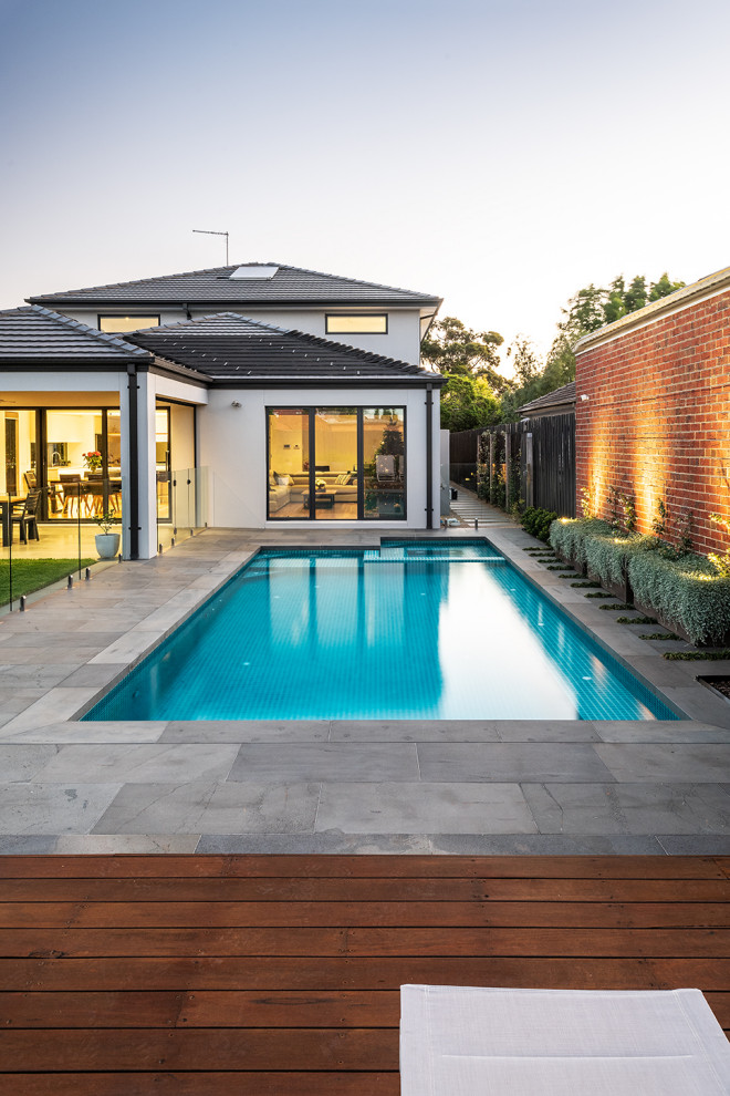 Ispirazione per una grande piscina minimal rettangolare dietro casa con paesaggistica bordo piscina e pedane