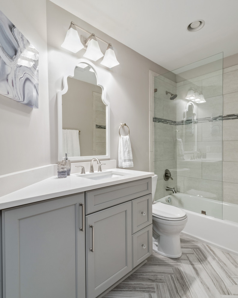 Design ideas for a small transitional kids bathroom in Charlotte with shaker cabinets, grey cabinets, an alcove tub, a shower/bathtub combo, gray tile, glass tile, grey walls, porcelain floors, an undermount sink, engineered quartz benchtops, grey floor, an open shower and white benchtops.