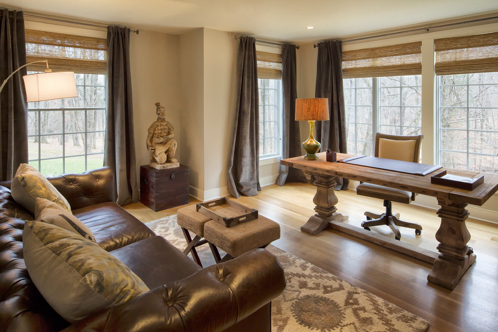 Traditional home office in New York with beige walls, medium hardwood floors, a freestanding desk and beige floor.