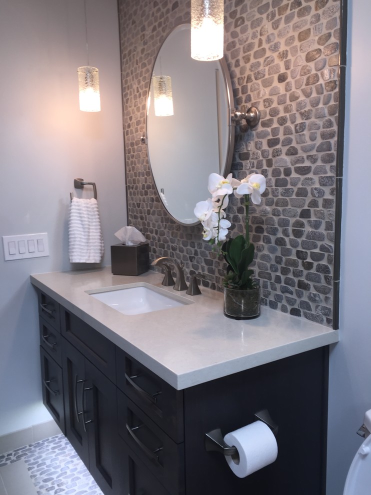 Design ideas for a mid-sized transitional kids bathroom in Phoenix with an undermount sink, shaker cabinets, dark wood cabinets, engineered quartz benchtops, an alcove tub, a shower/bathtub combo, gray tile, pebble tile, blue walls and pebble tile floors.