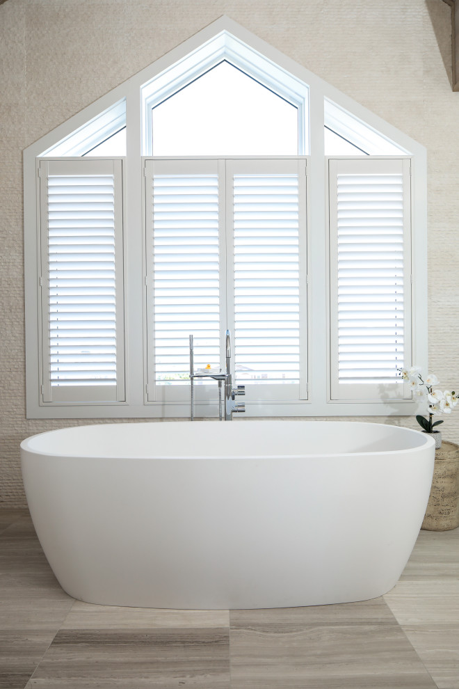 Ejemplo de cuarto de baño principal minimalista con bañera exenta, paredes beige, suelo de madera en tonos medios y papel pintado