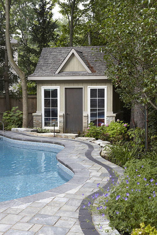 Large contemporary backyard custom-shaped natural pool in Toronto with a water feature and brick pavers.