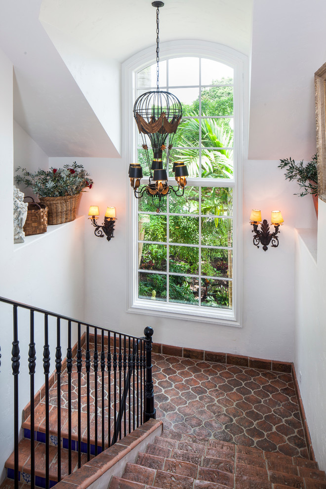 This is an example of a mediterranean tile u-shaped staircase in Miami with tile risers.
