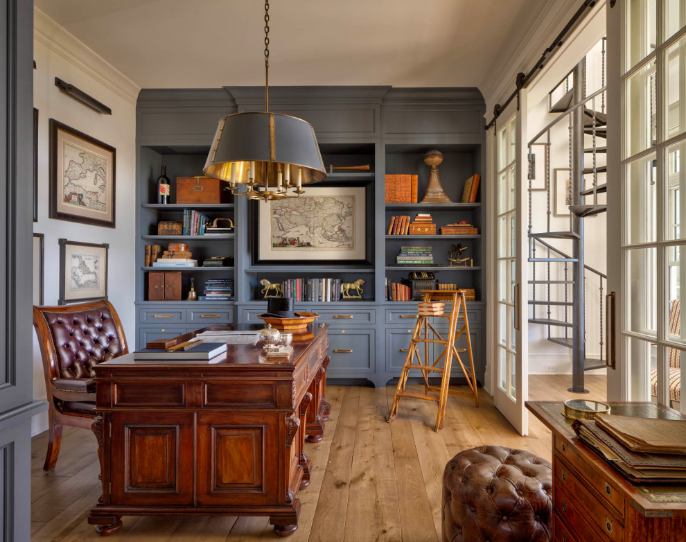Inspiration för ett stort rustikt hemmabibliotek, med blå väggar, mellanmörkt trägolv, ett fristående skrivbord och brunt golv