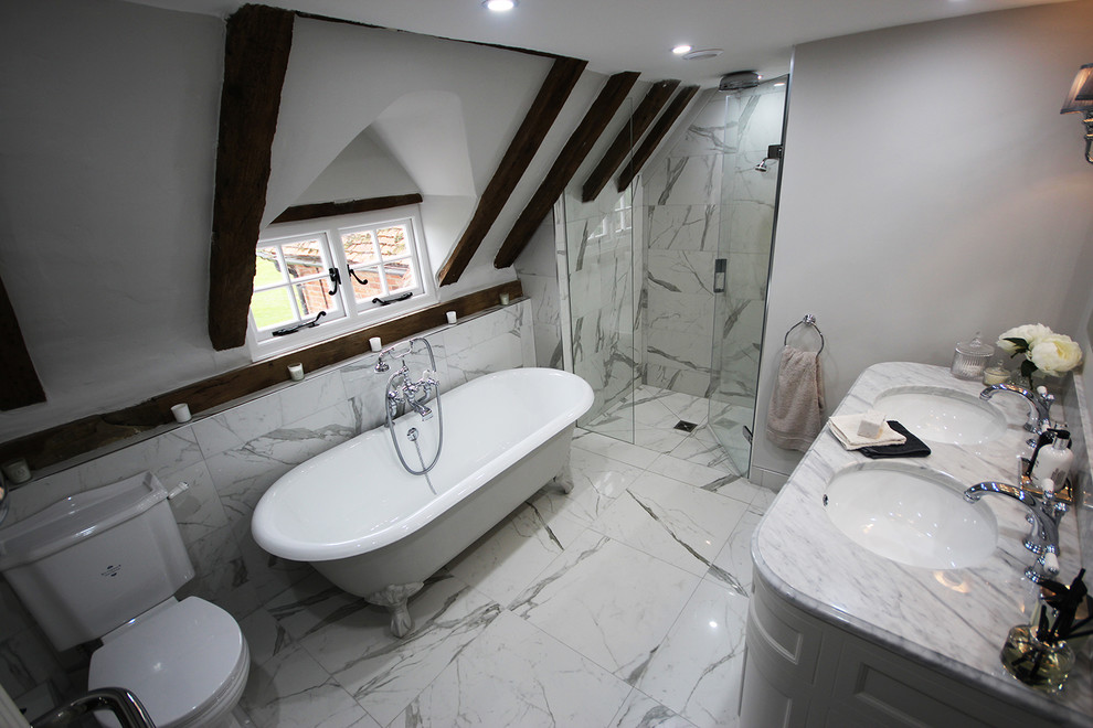 Inspiration for a mid-sized traditional master wet room bathroom in Surrey with furniture-like cabinets, grey cabinets, a claw-foot tub, a two-piece toilet, black and white tile, porcelain tile, grey walls, porcelain floors, an undermount sink, marble benchtops and a hinged shower door.