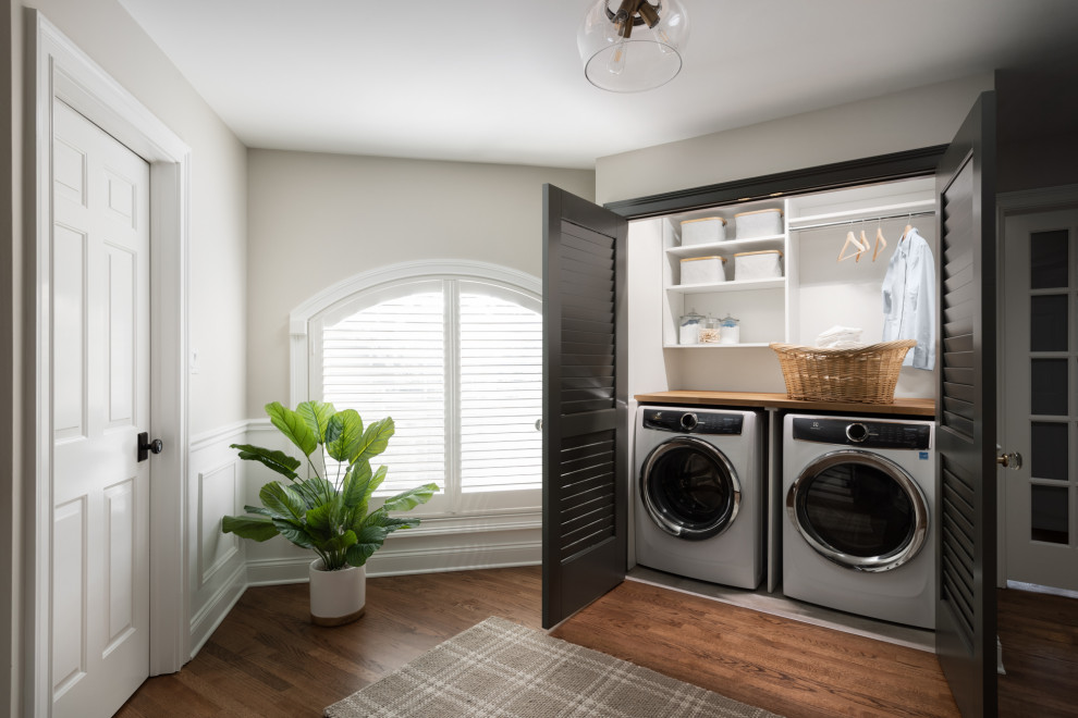 Small traditional laundry cupboard in Chicago with wood benchtops, medium hardwood floors and a side-by-side washer and dryer.