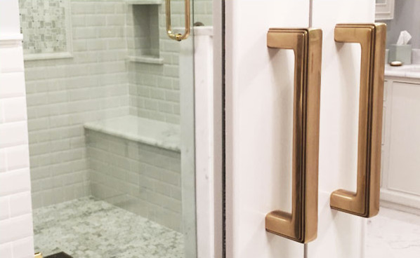 Drop-in bathtub - white tile and ceramic tile marble floor drop-in bathtub idea in Jackson with a drop-in sink, glass-front cabinets, white cabinets, marble countertops and white walls